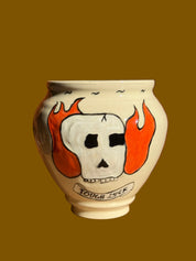Decorative ceramic vase with a ghost design on a wooden surface