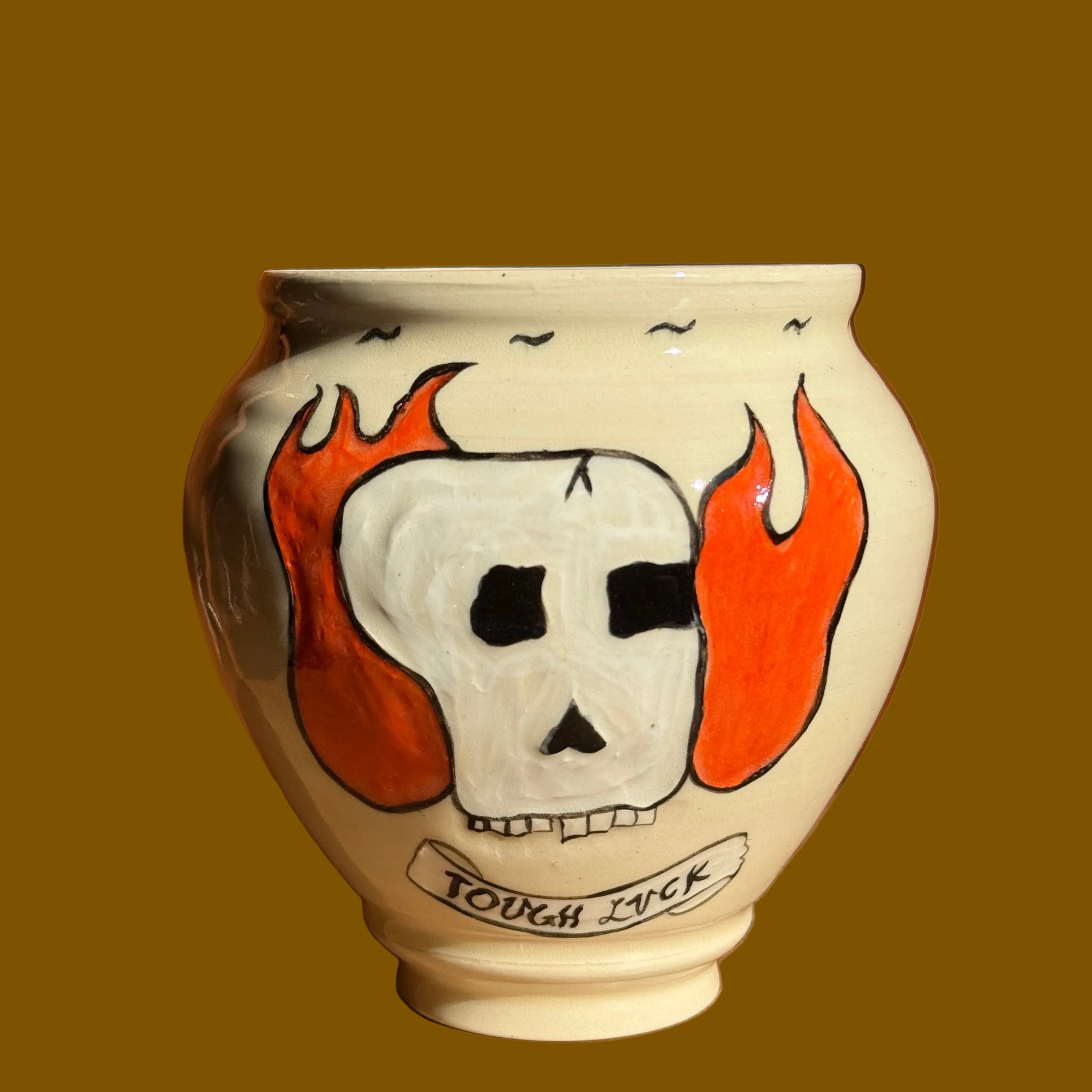 Decorative ceramic vase with a ghost design on a wooden surface