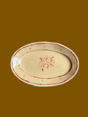 Oval ceramic plate with floral design on a gray surface