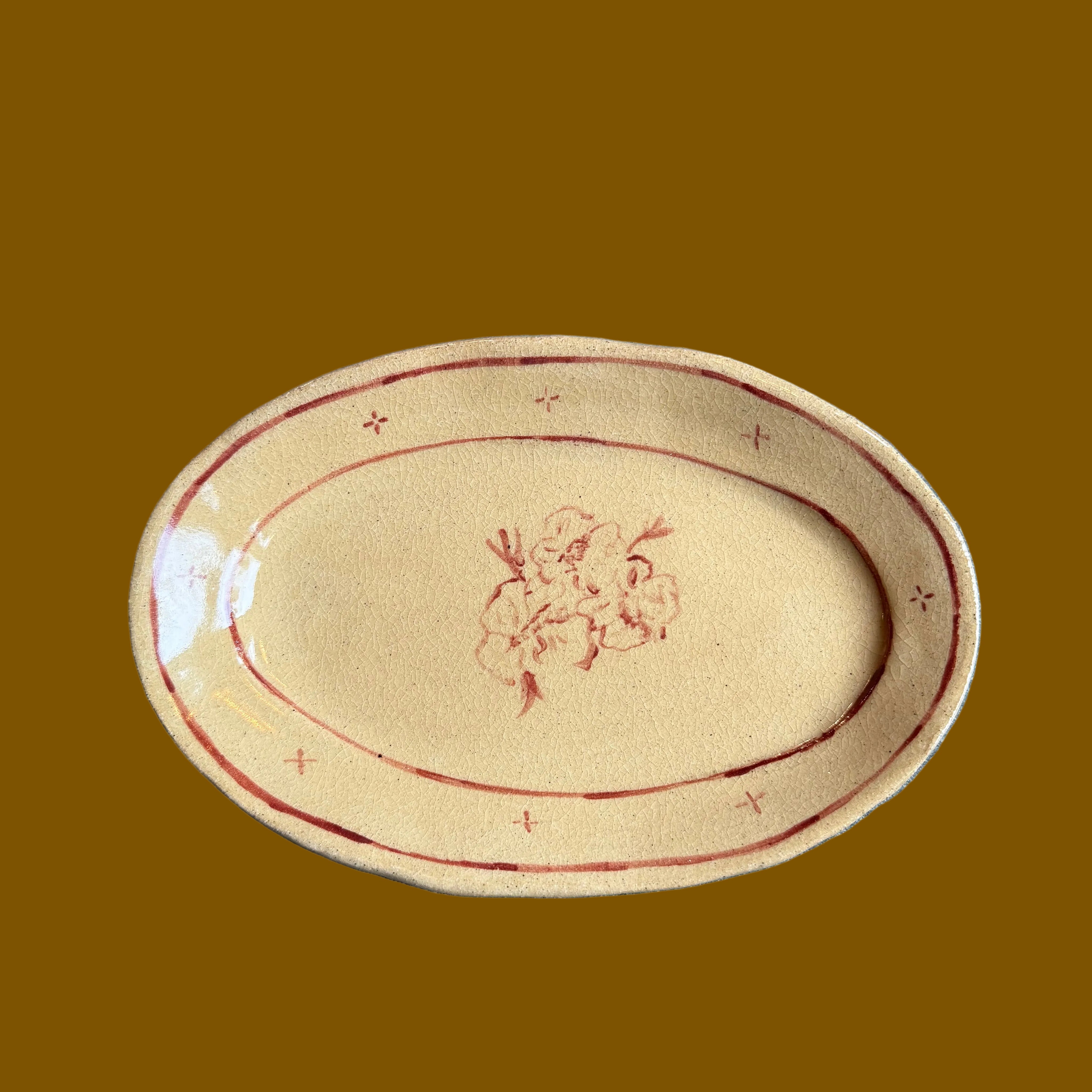 Oval ceramic plate with floral design on a gray surface
