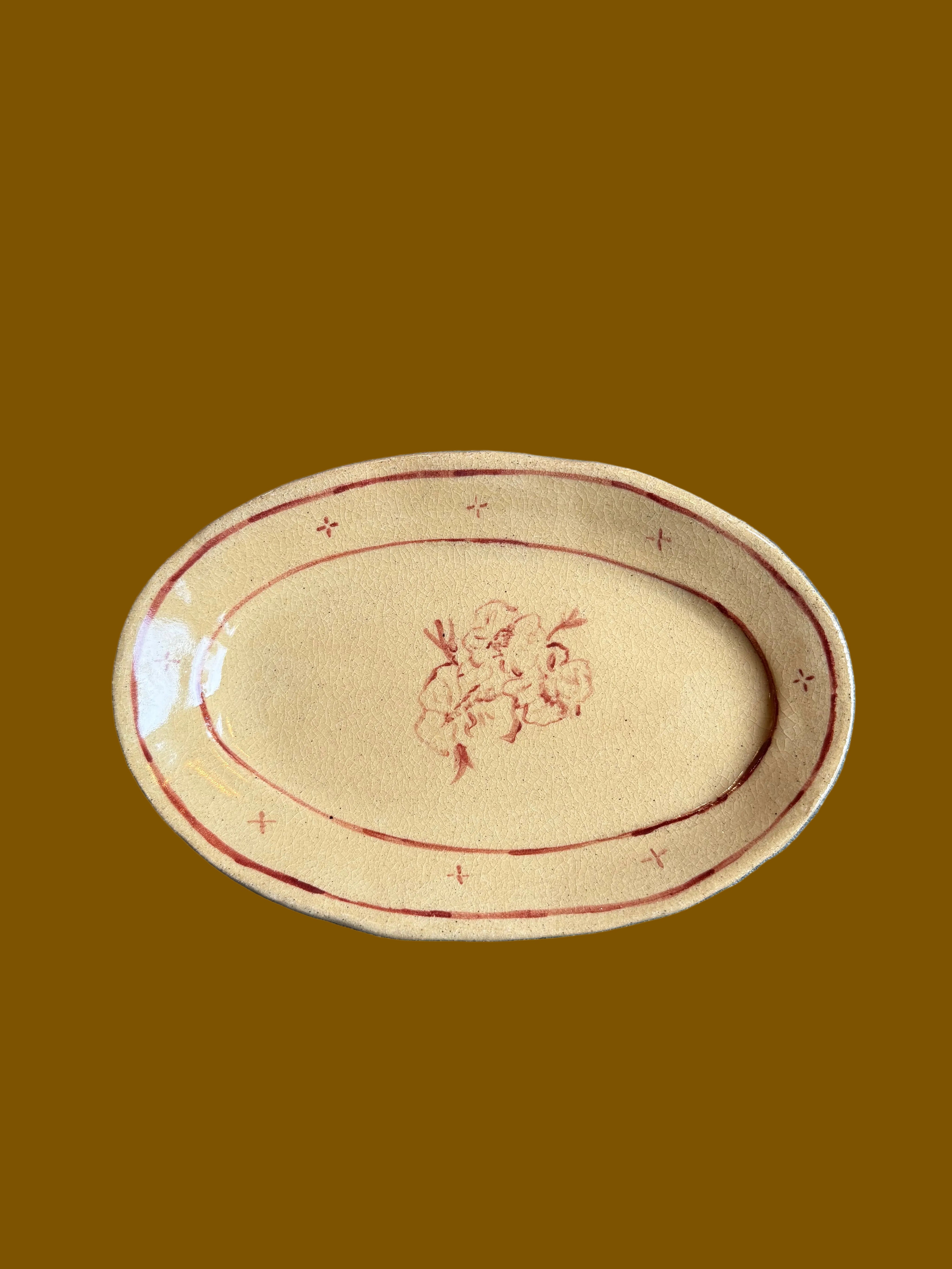 Oval ceramic plate with floral design on a gray surface