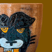 Ceramic cup with a painted panther design on a brown background